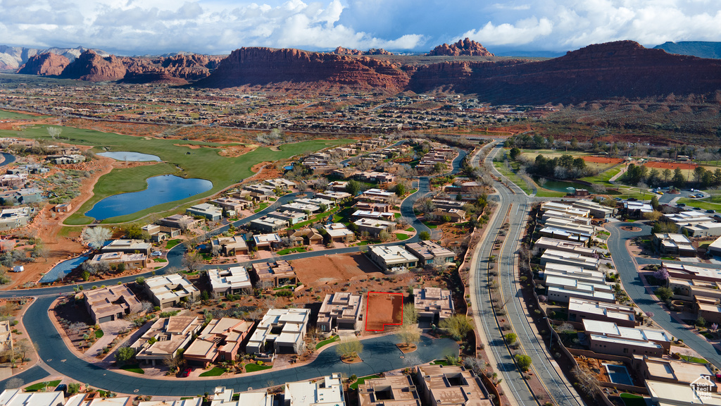 Aerial view of property and surrounding area with a water and mountain view, nearby suburban area, and a golf club