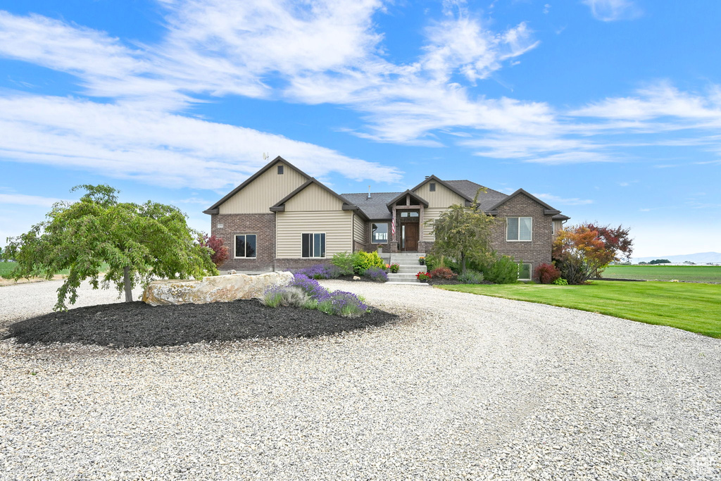 View of front of property with brick siding, driveway, and a front yard