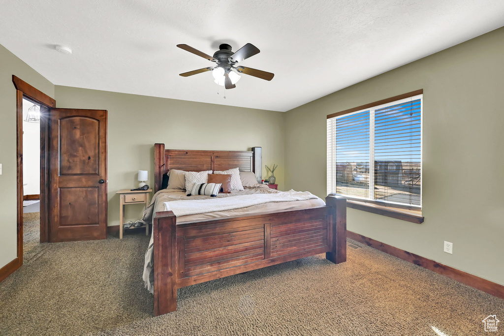 Carpeted bedroom featuring ceiling fan
