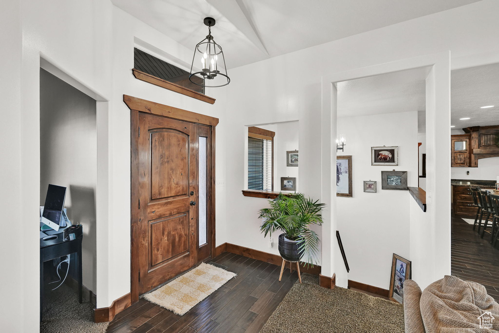 Entryway with dark hardwood / wood-style flooring and an inviting chandelier