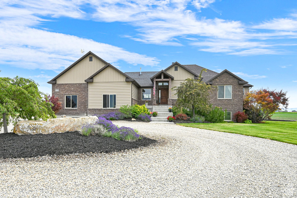 Craftsman inspired home with brick siding, driveway, and a front yard