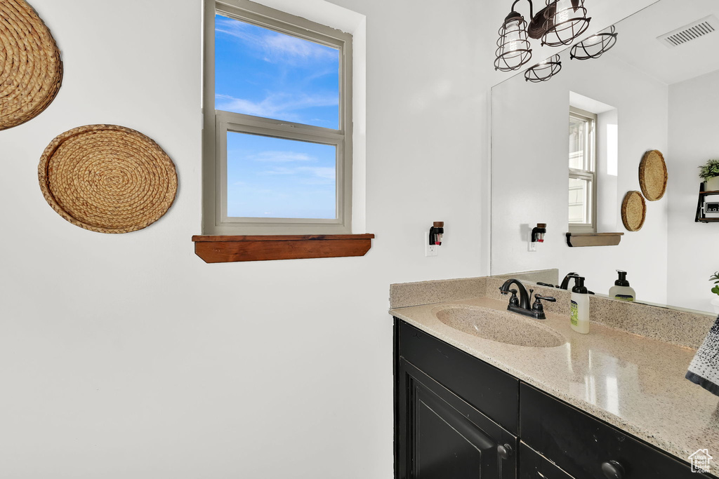 Bathroom featuring a chandelier and vanity