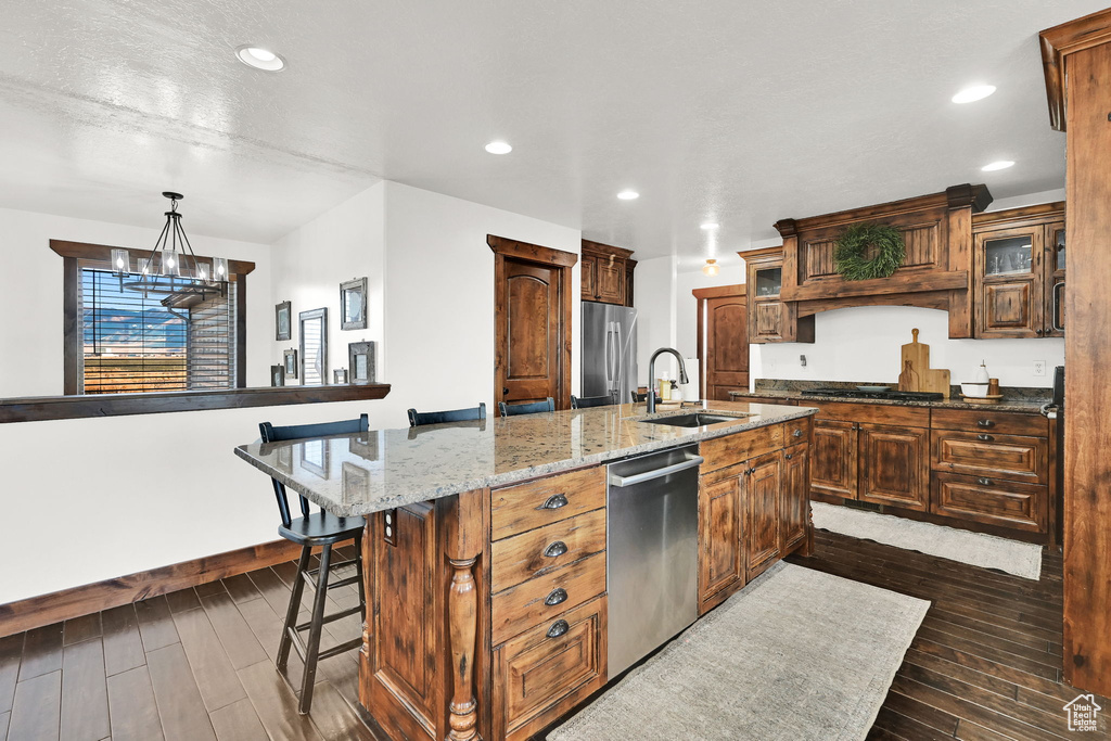 Kitchen featuring pendant lighting, a notable chandelier, sink, a large island, and stainless steel appliances