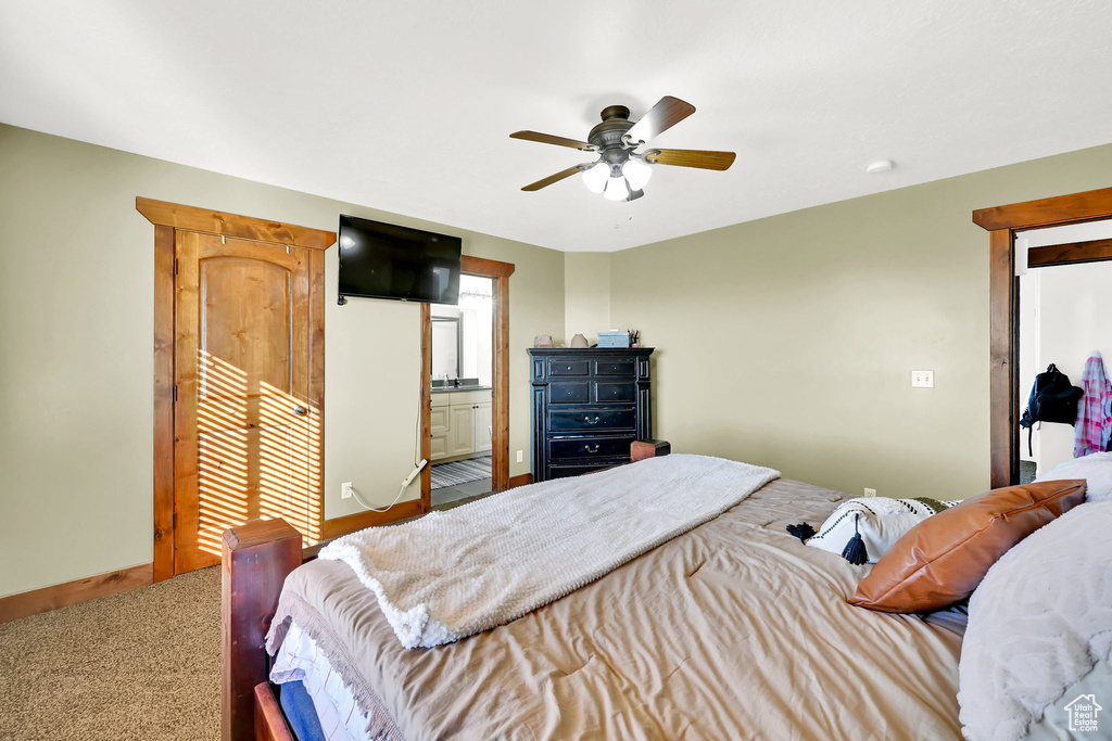 Carpeted bedroom with ceiling fan and ensuite bath