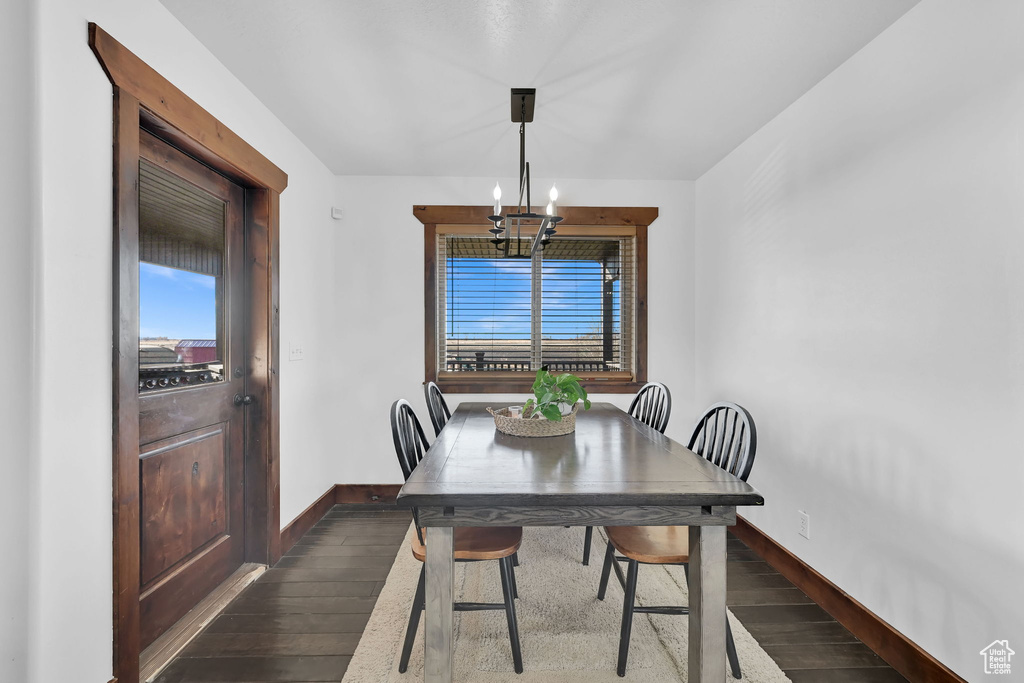 Dining room with a chandelier and dark hardwood / wood-style flooring