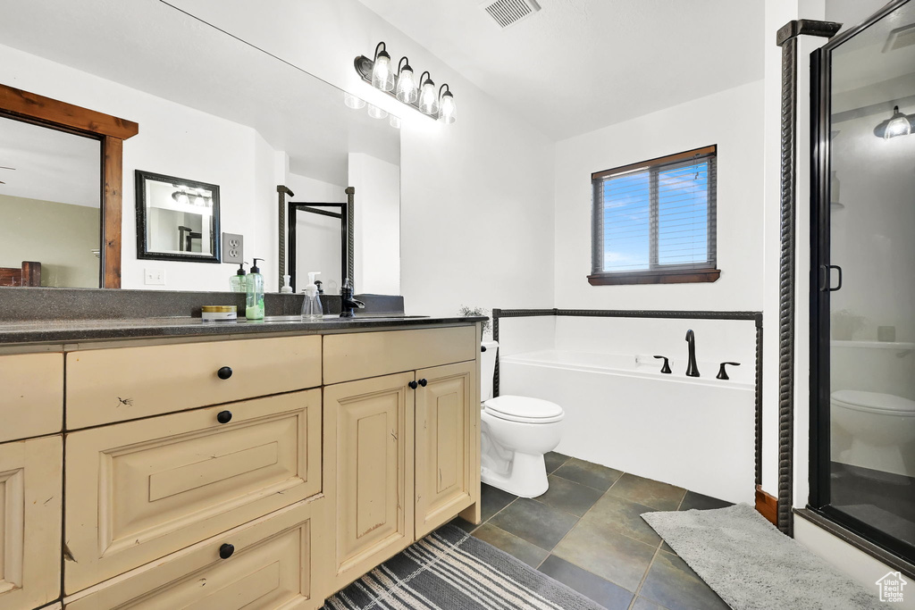 Full bathroom featuring plus walk in shower, vanity, and toilet