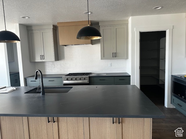 Kitchen featuring range, dark countertops, dark wood-style floors, tasteful backsplash, and a textured ceiling