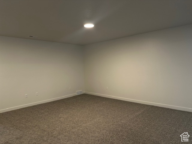 Spare room with dark colored carpet and recessed lighting
