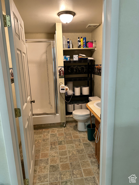 Full bath featuring a shower stall, stone finish floors, and vanity