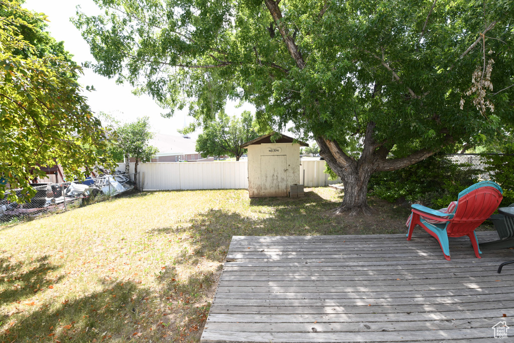 Wooden deck with a fenced backyard and a shed