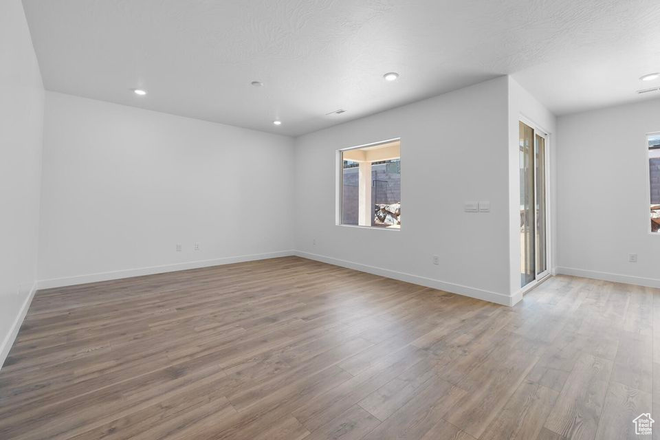 Spare room with wood finished floors and recessed lighting