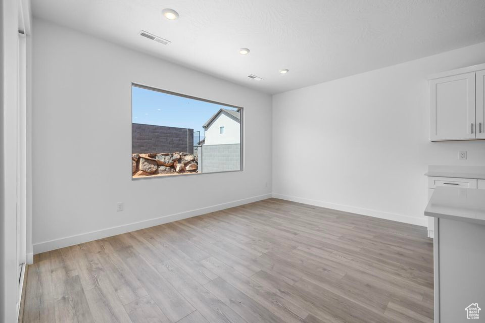 Spare room with light wood finished floors and recessed lighting