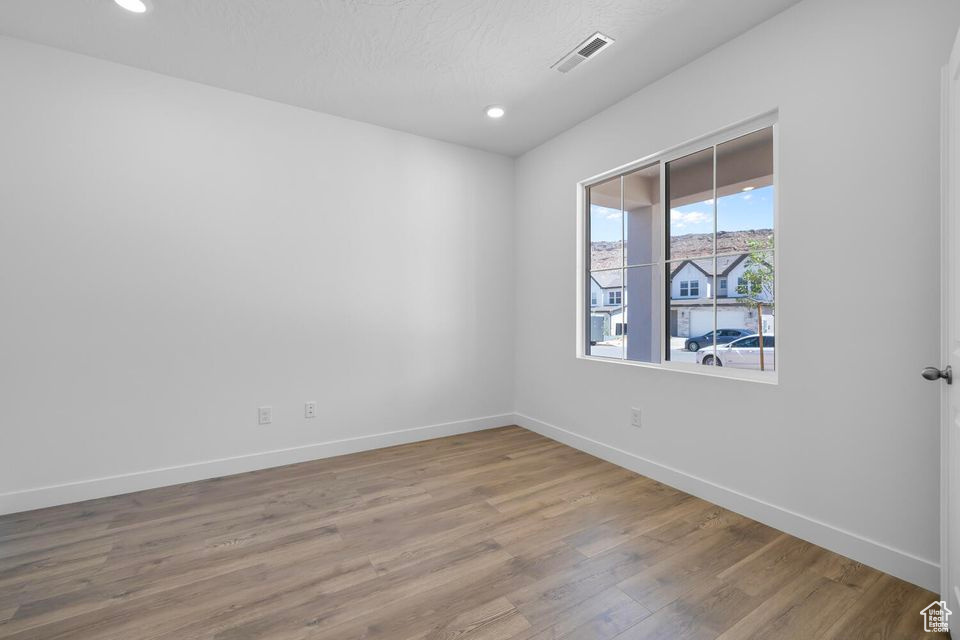 Empty room featuring wood finished floors and recessed lighting