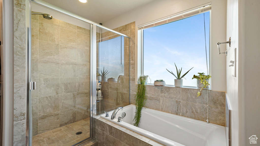 Full bathroom featuring a garden tub, a stall shower, and healthy amount of natural light