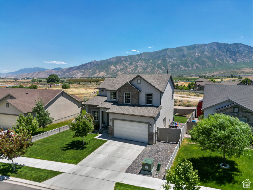 Traditional-style house with stucco siding, a gate, driveway, a mountain view, and an attached garage