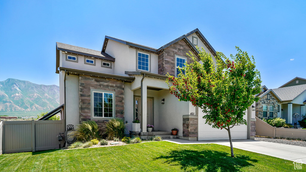 Traditional-style house with stone siding, driveway, stucco siding, and a mountain view