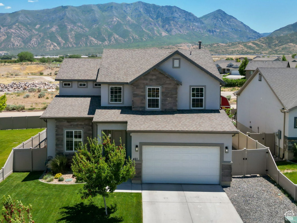 Traditional-style home featuring stone siding, stucco siding, driveway, and a shingled roof