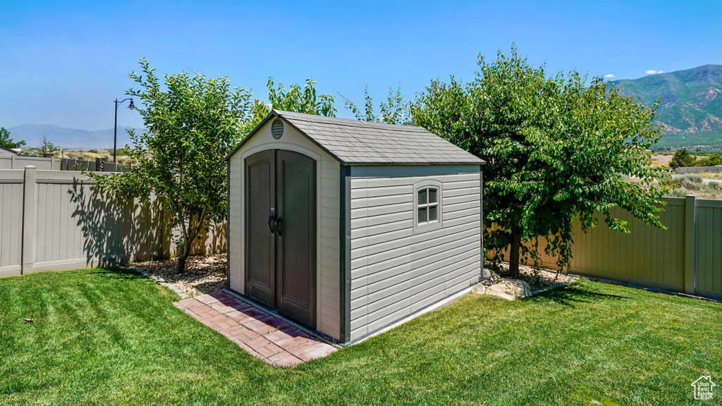View of shed with a fenced backyard and a mountain view