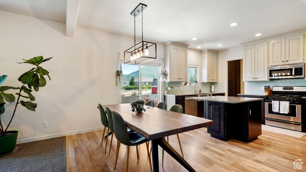 Kitchen featuring stainless steel appliances, light wood-style flooring, backsplash, recessed lighting, and light stone countertops