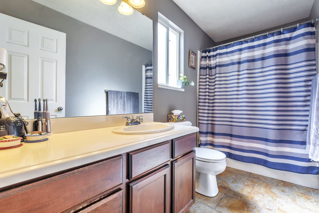 Bathroom with vanity, stone finish floors, and a shower with shower curtain