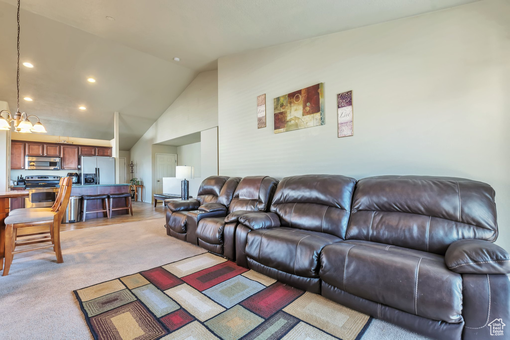 Living area with a chandelier, lofted ceiling, recessed lighting, and light carpet