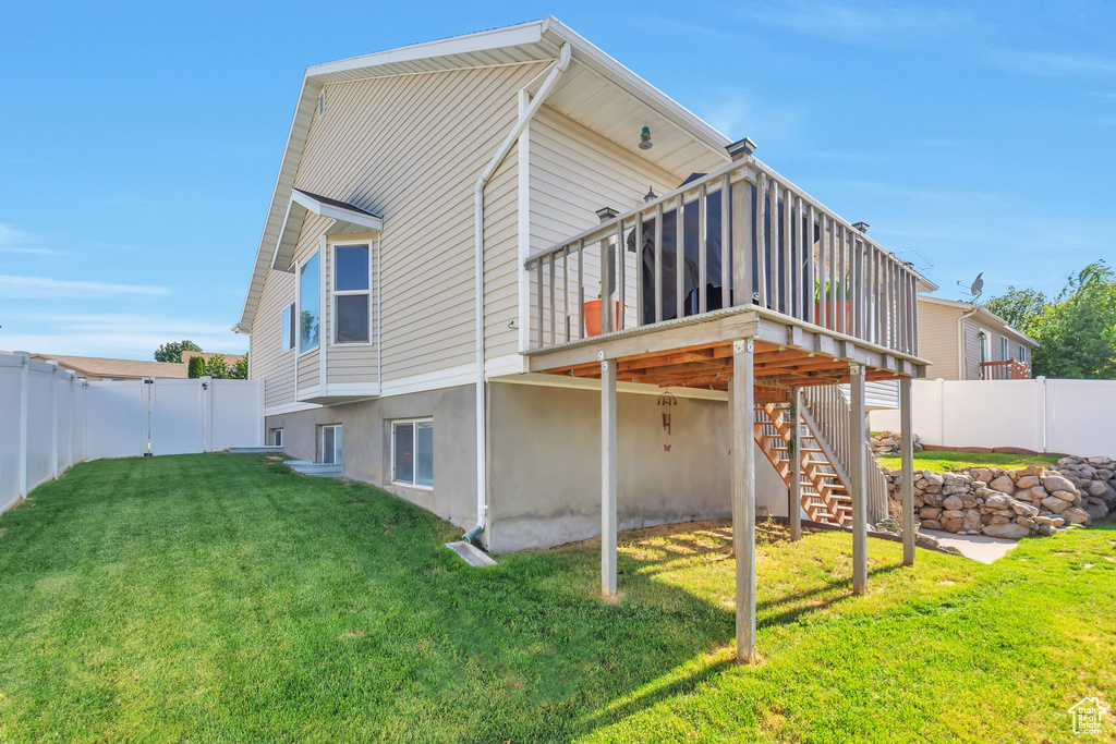 Back of house featuring a fenced backyard, a deck, and stairway