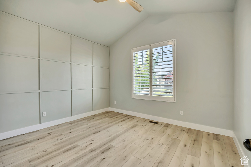 Spare room featuring ceiling fan, wood finished floors, and lofted ceiling
