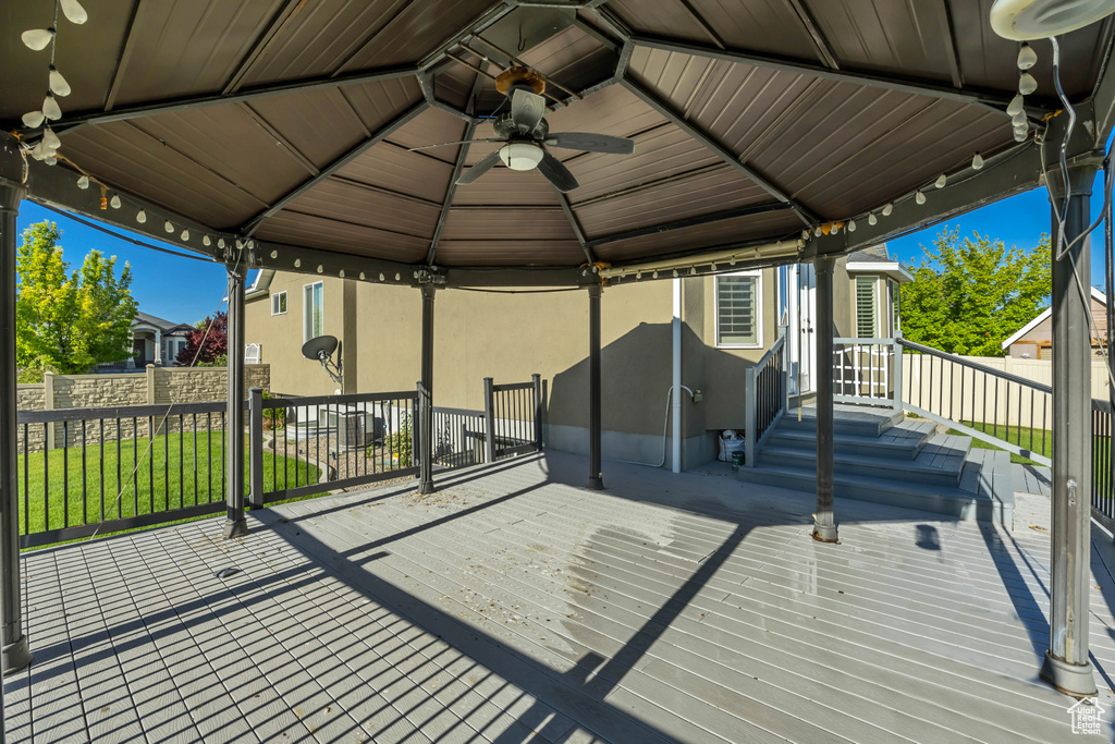 Wooden deck featuring a gazebo and ceiling fan