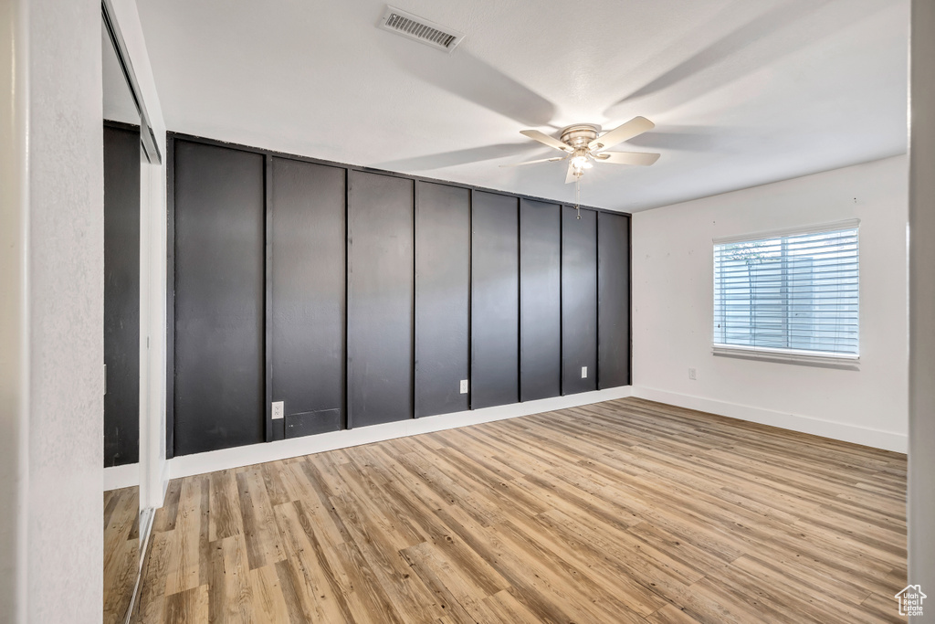 Empty room featuring a ceiling fan and wood finished floors