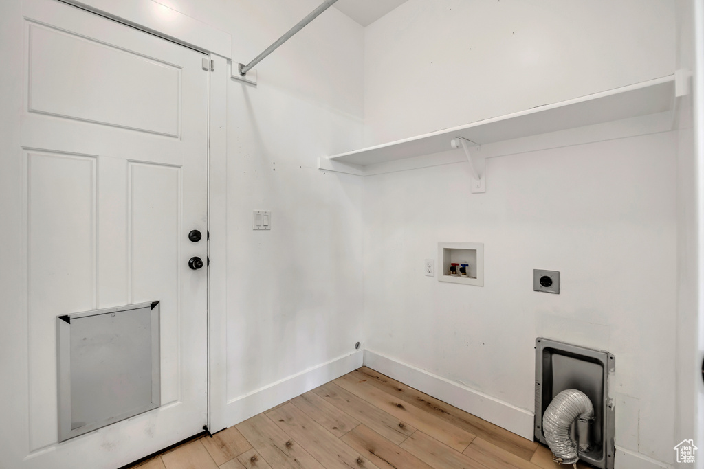 Washroom with hookup for an electric dryer, light wood-style flooring, and hookup for a washing machine
