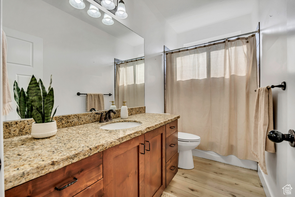 Full bath with vanity, wood finished floors, and shower / bath combo