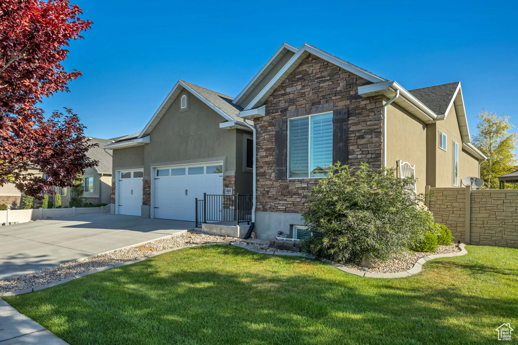 View of front of home featuring stone siding, stucco siding, concrete driveway, and a garage