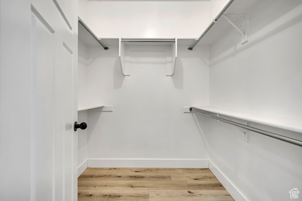 Walk in closet with light wood-style floors