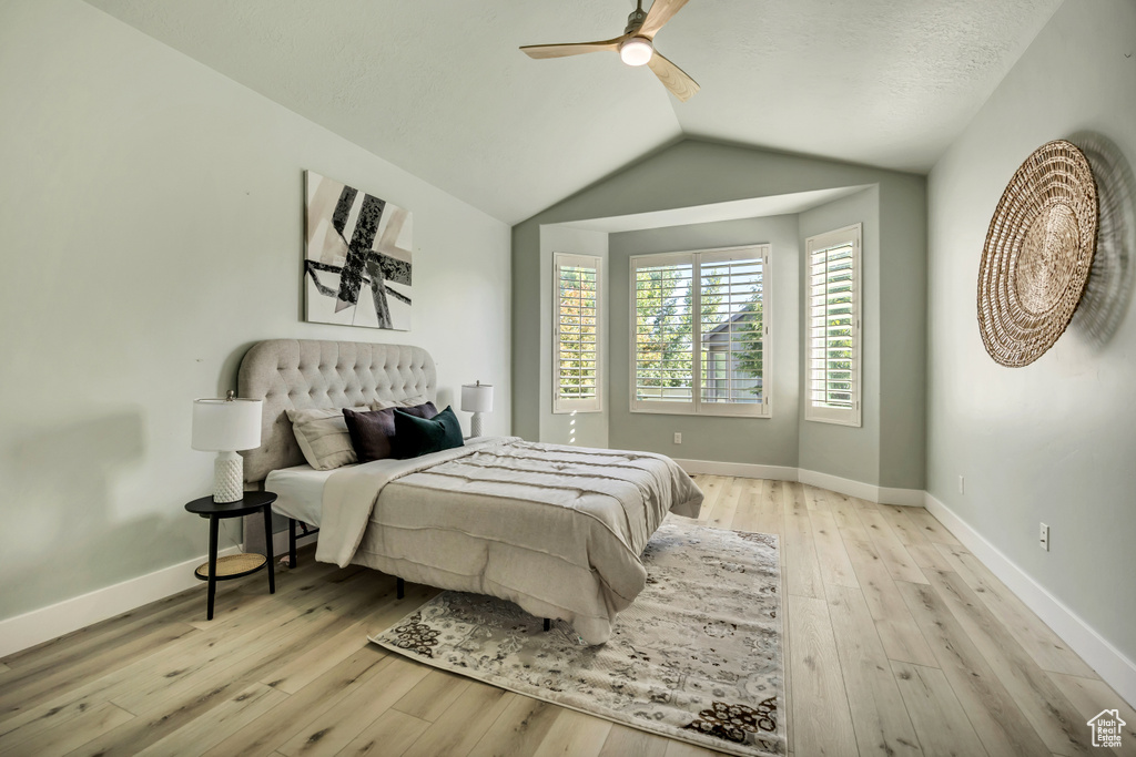 Bedroom featuring wood-type flooring, vaulted ceiling, and a ceiling fan
