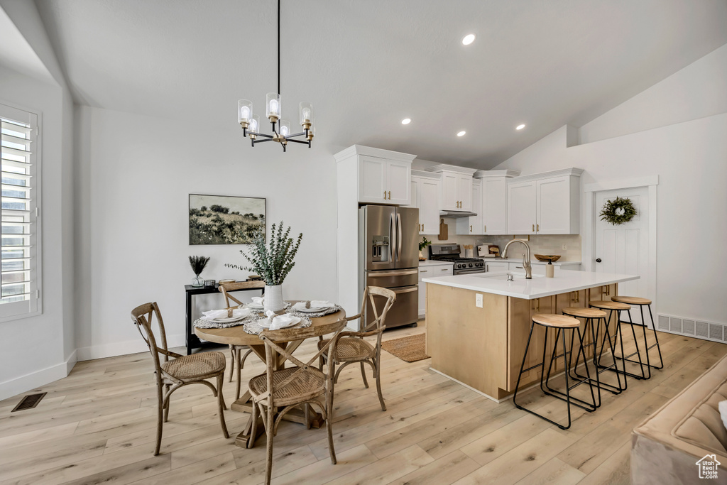 Kitchen with appliances with stainless steel finishes, light countertops, recessed lighting, a chandelier, and light wood finished floors