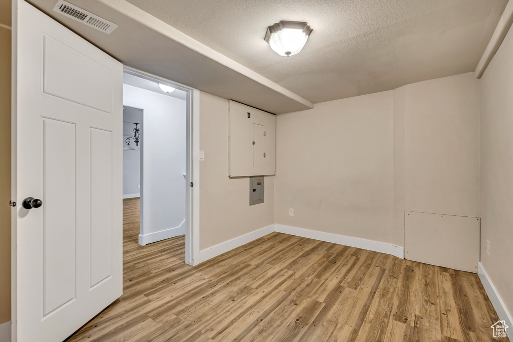 Spare room featuring light wood finished floors and a textured ceiling