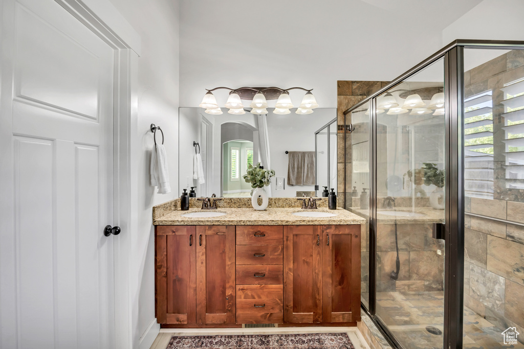 Bathroom featuring double vanity and a shower stall
