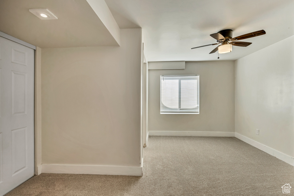 Carpeted empty room with baseboards and ceiling fan