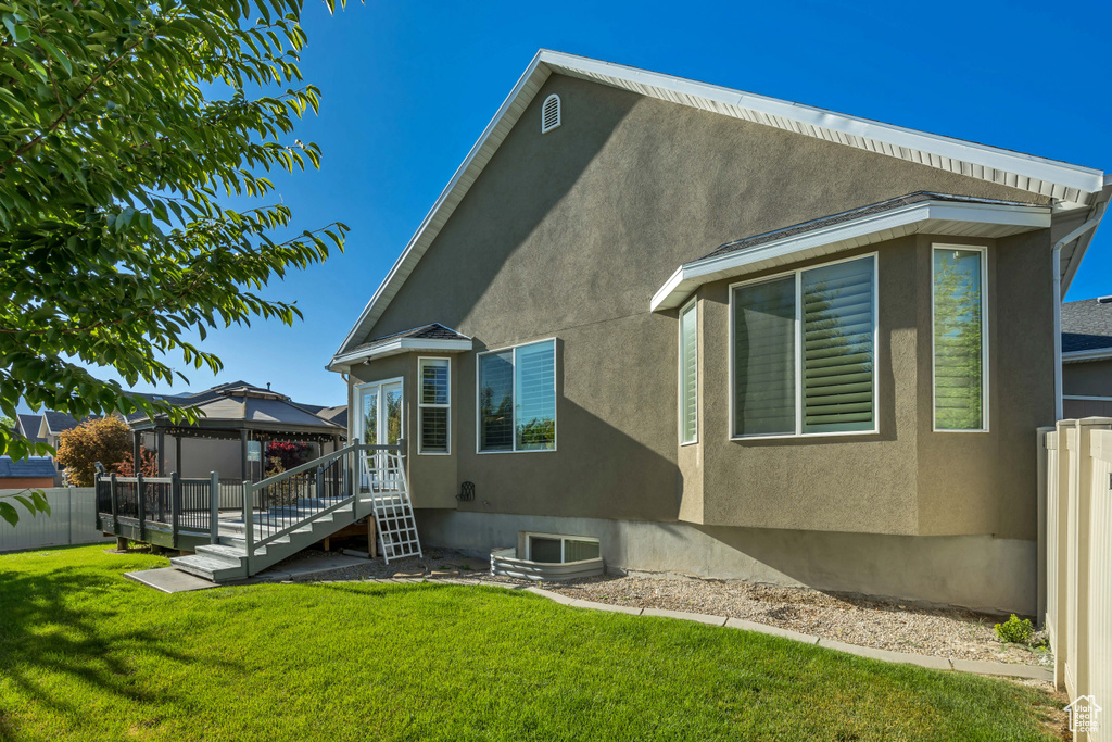 Rear view of property featuring a gazebo and stucco siding