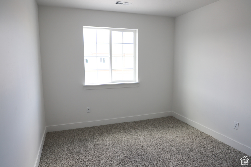 Carpeted empty room with baseboards
