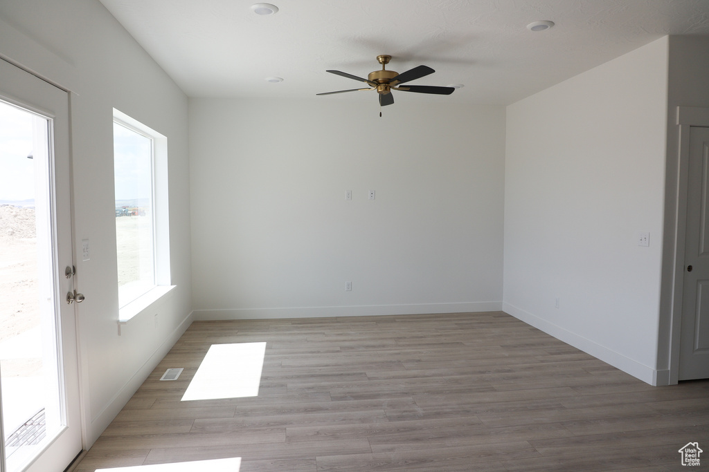 Spare room with a ceiling fan and light wood-style floors