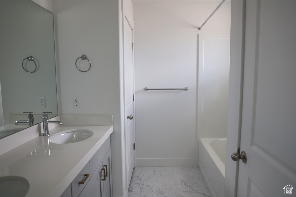Full bath with marble look tiles and double vanity
