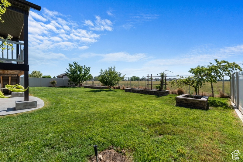 Fenced backyard with a garden and a balcony