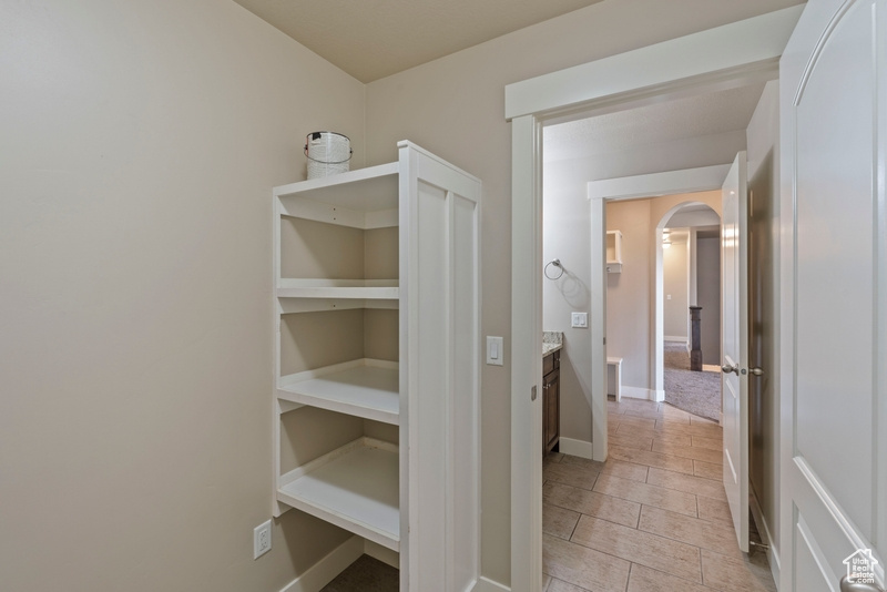 Hallway with arched walkways and baseboards