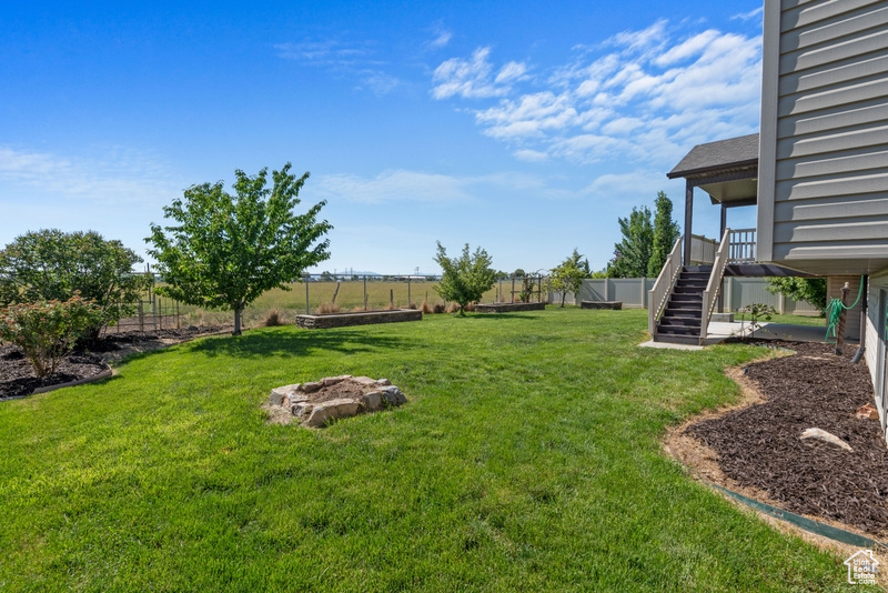Fenced backyard with stairway and a fire pit