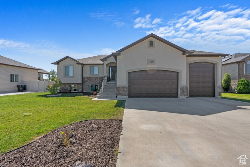 French country style house featuring an attached garage, concrete driveway, stone siding, and stucco siding
