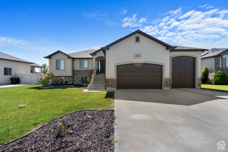 View of front of house featuring stucco siding, an attached garage, concrete driveway, and stone siding