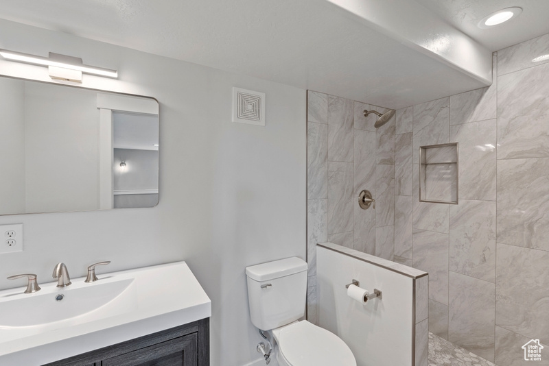 Bathroom featuring a walk in shower and vanity