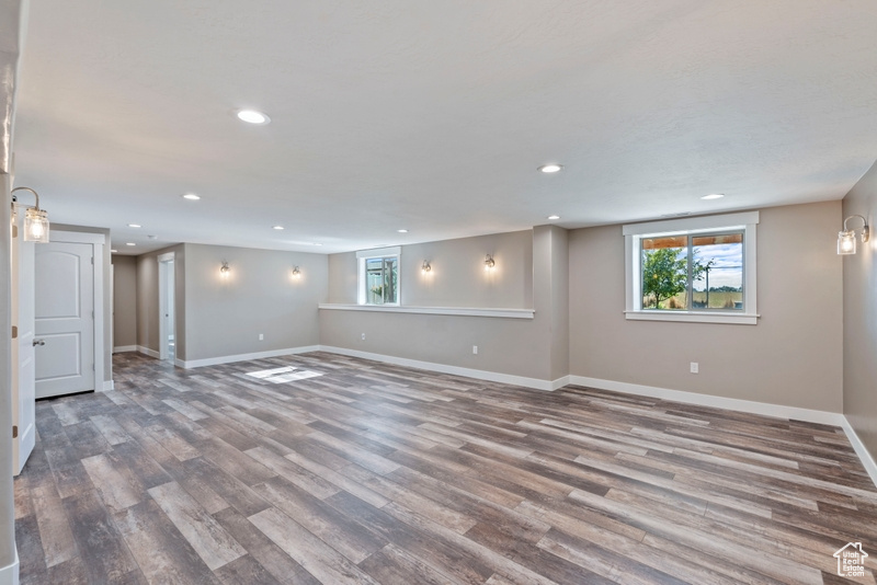 Basement featuring recessed lighting, wood finished floors, and plenty of natural light