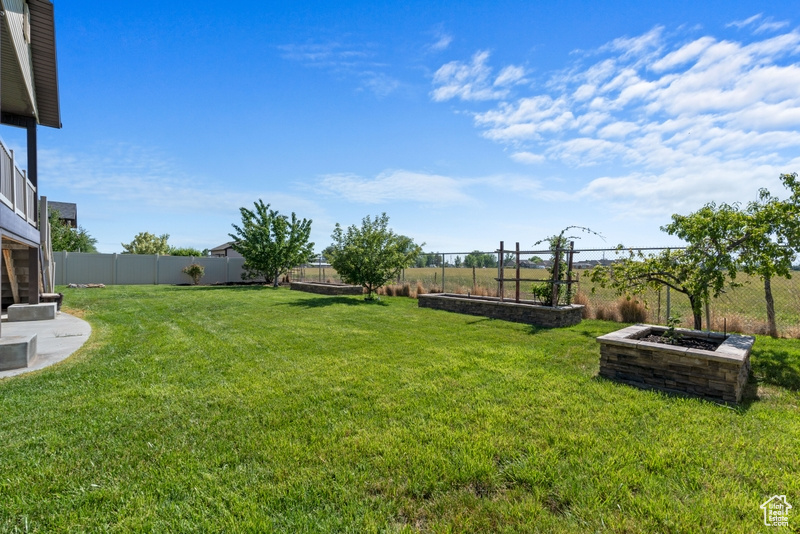 Fenced backyard featuring a vegetable garden